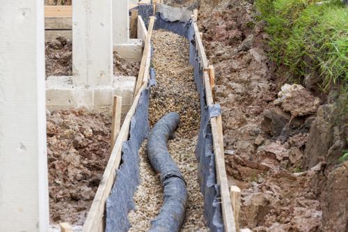 A French drain system being installed in a yard.