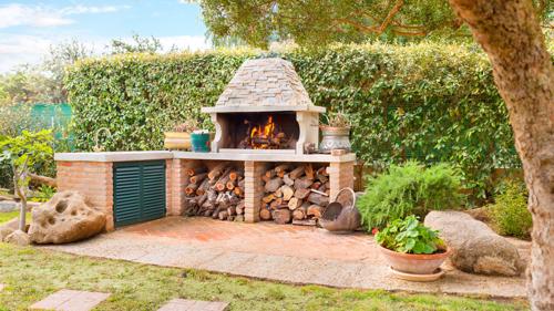 An outdoor fireplace made of brick on a patio.