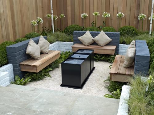 A fenced off outdoor patio with couches and a table. 